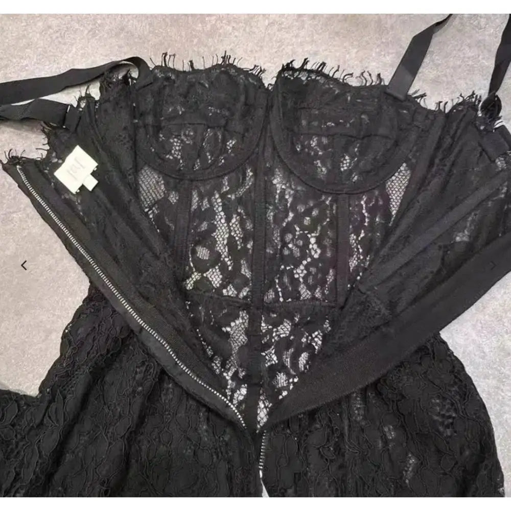Black lace garment with a brand label on a neutral background